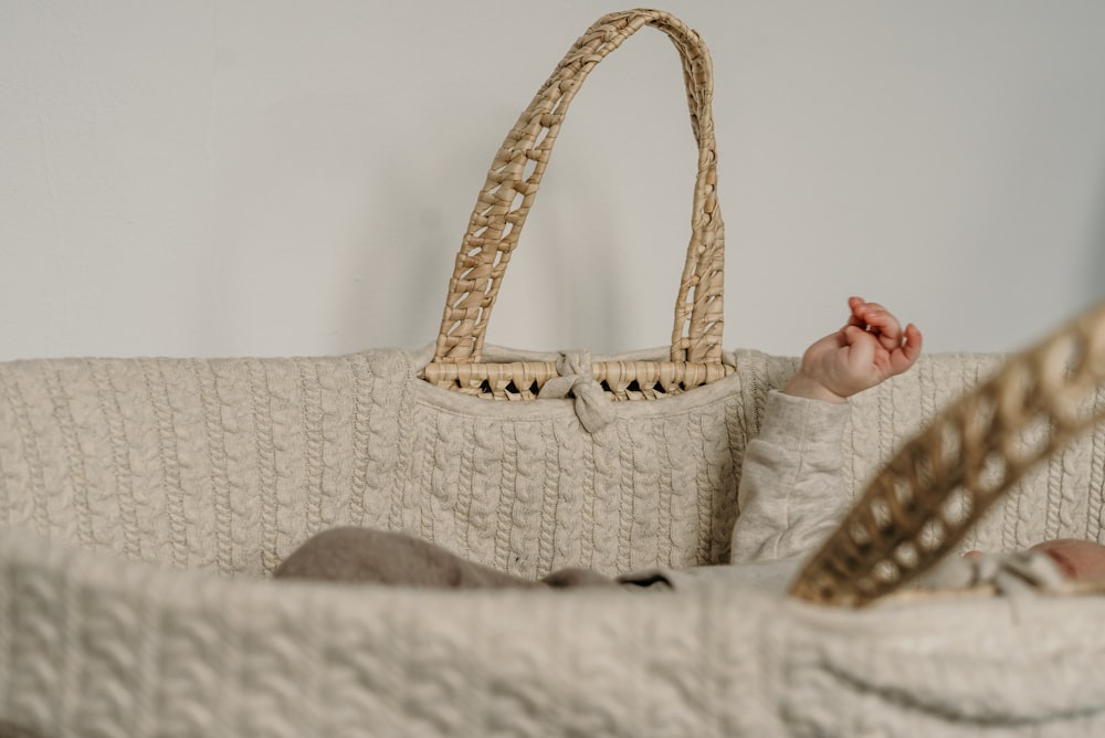 a baby laying in a crib with a basket on top of it