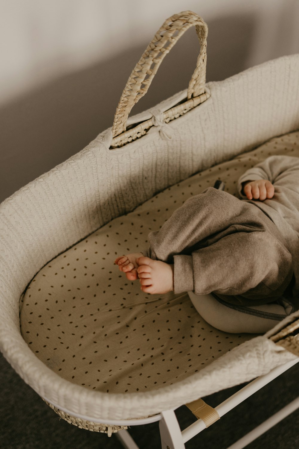a baby laying in a crib with a handbag on top of it