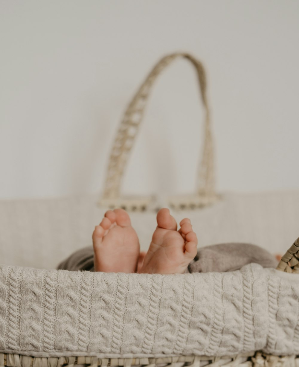 a baby laying in a basket with a book