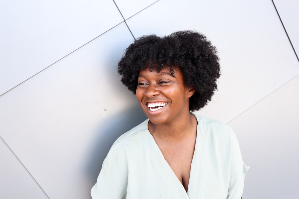 a woman with an afro is smiling for the camera