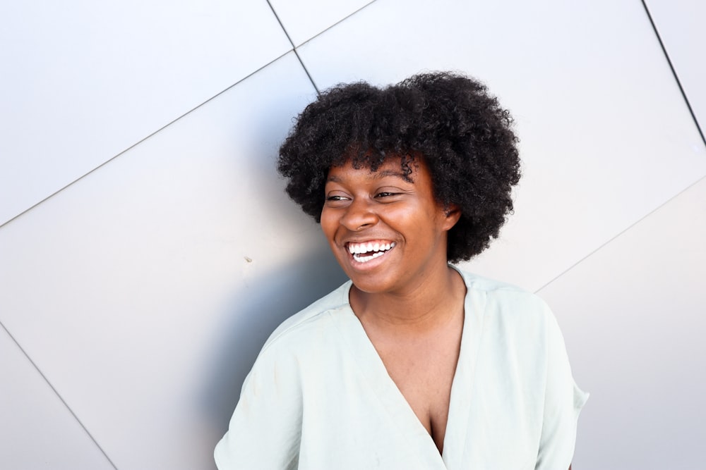 Una mujer con un afro está sonriendo para la cámara