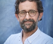 a man with a beard and glasses posing for a picture