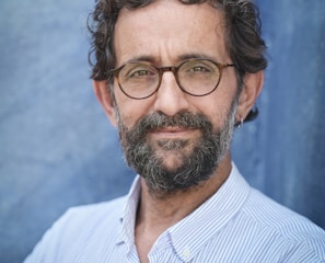 a man with a beard and glasses posing for a picture