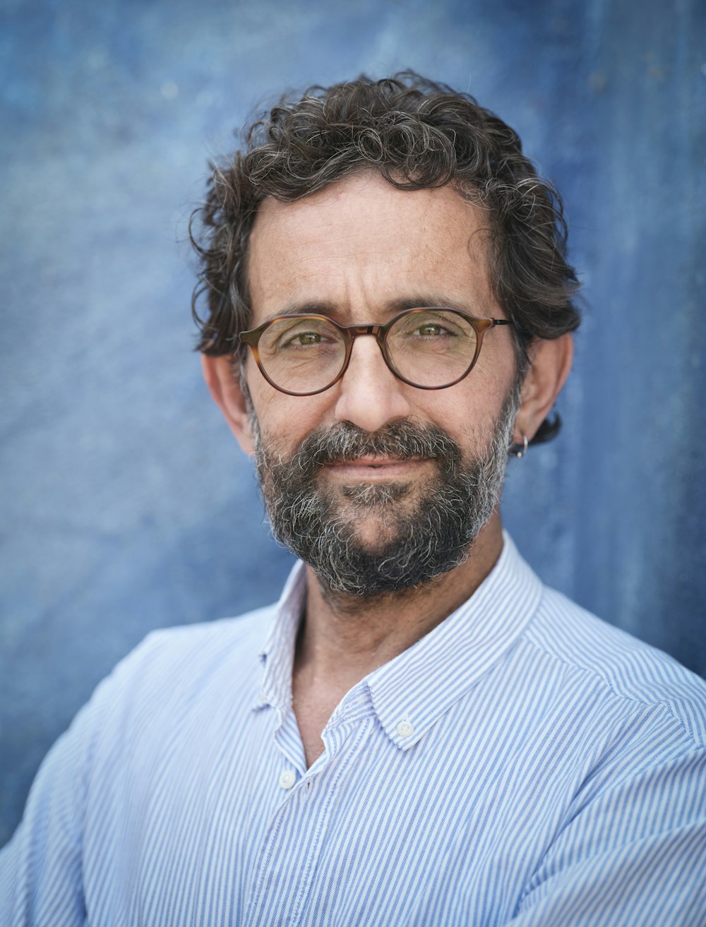 a man with a beard and glasses posing for a picture