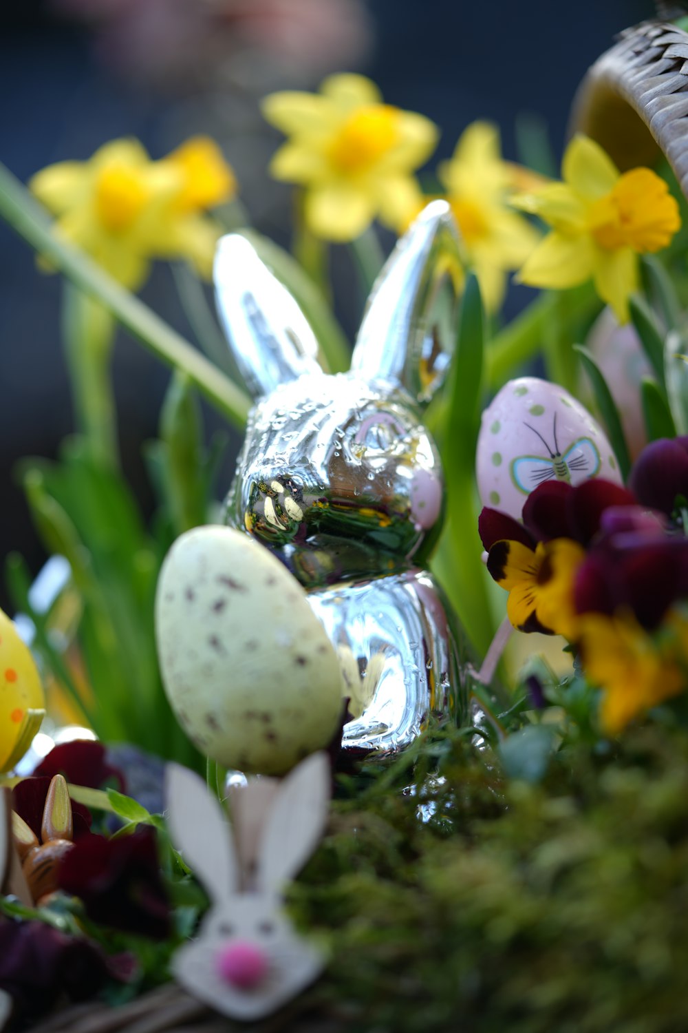 a close up of a basket of eggs and flowers