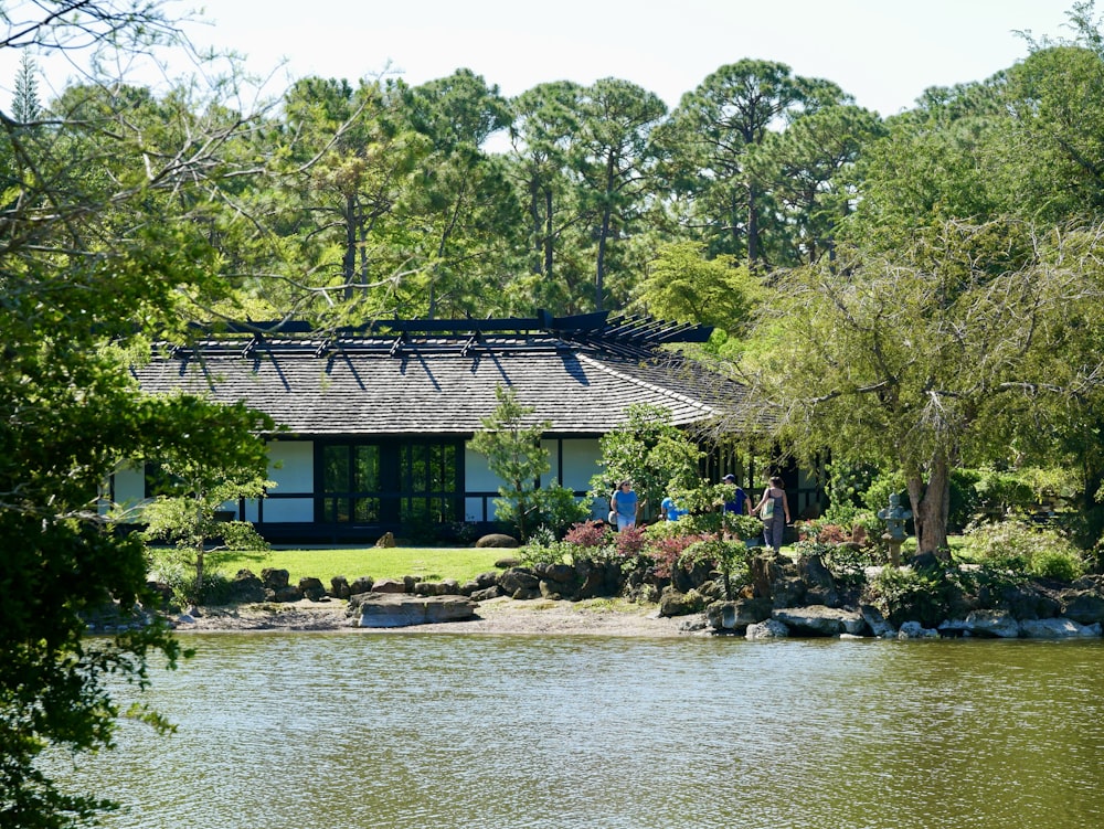 a house sitting next to a lake surrounded by trees