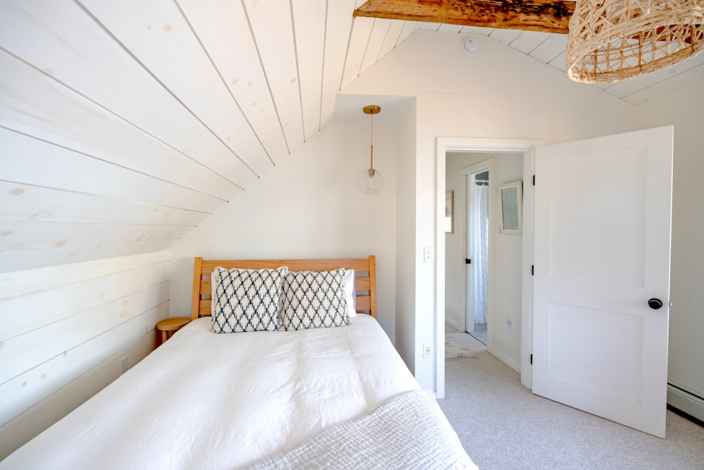 a bedroom with white walls and a white bed