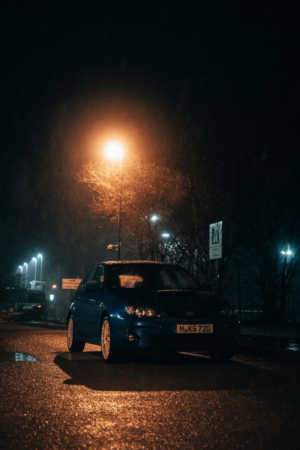 a car parked on the side of the road at night
