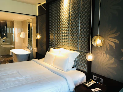 A modern bedroom featuring soft linens, elegant decor, and ambient lighting.