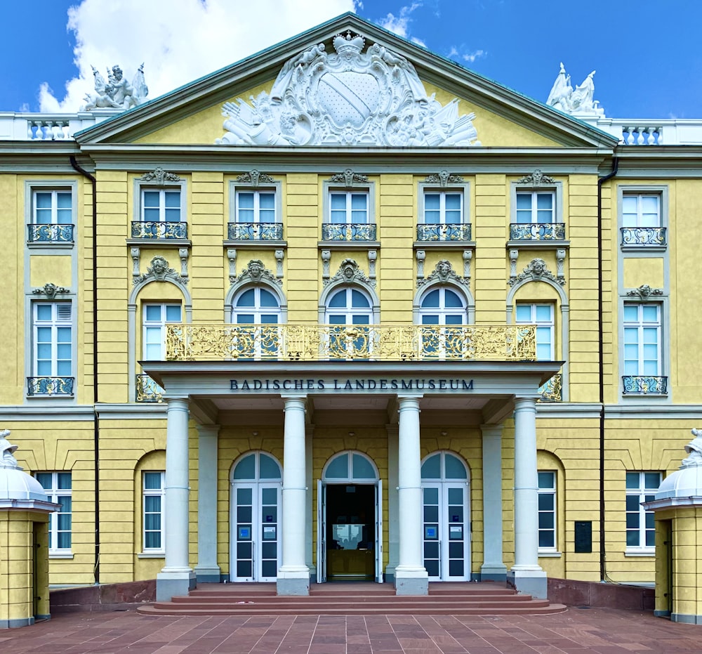 ein großes gelbes Gebäude mit einer Uhr auf der Vorderseite