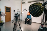 a woman sitting in a chair in front of a camera