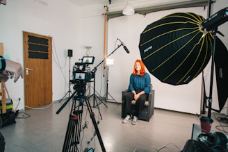 a woman sitting in a chair in front of a camera
