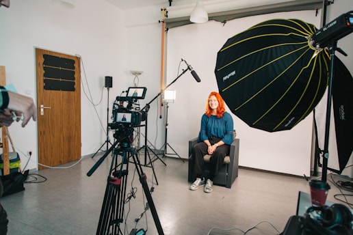 a woman sitting in a chair in front of a camera