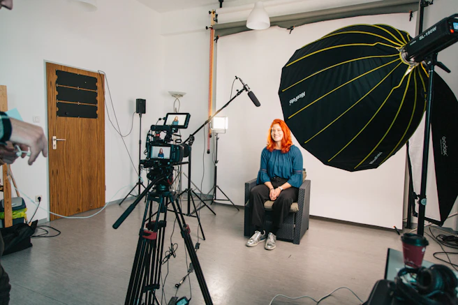 a woman sitting in a chair in front of a camera