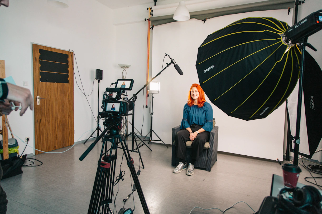 a woman sitting in a chair in front of a camera