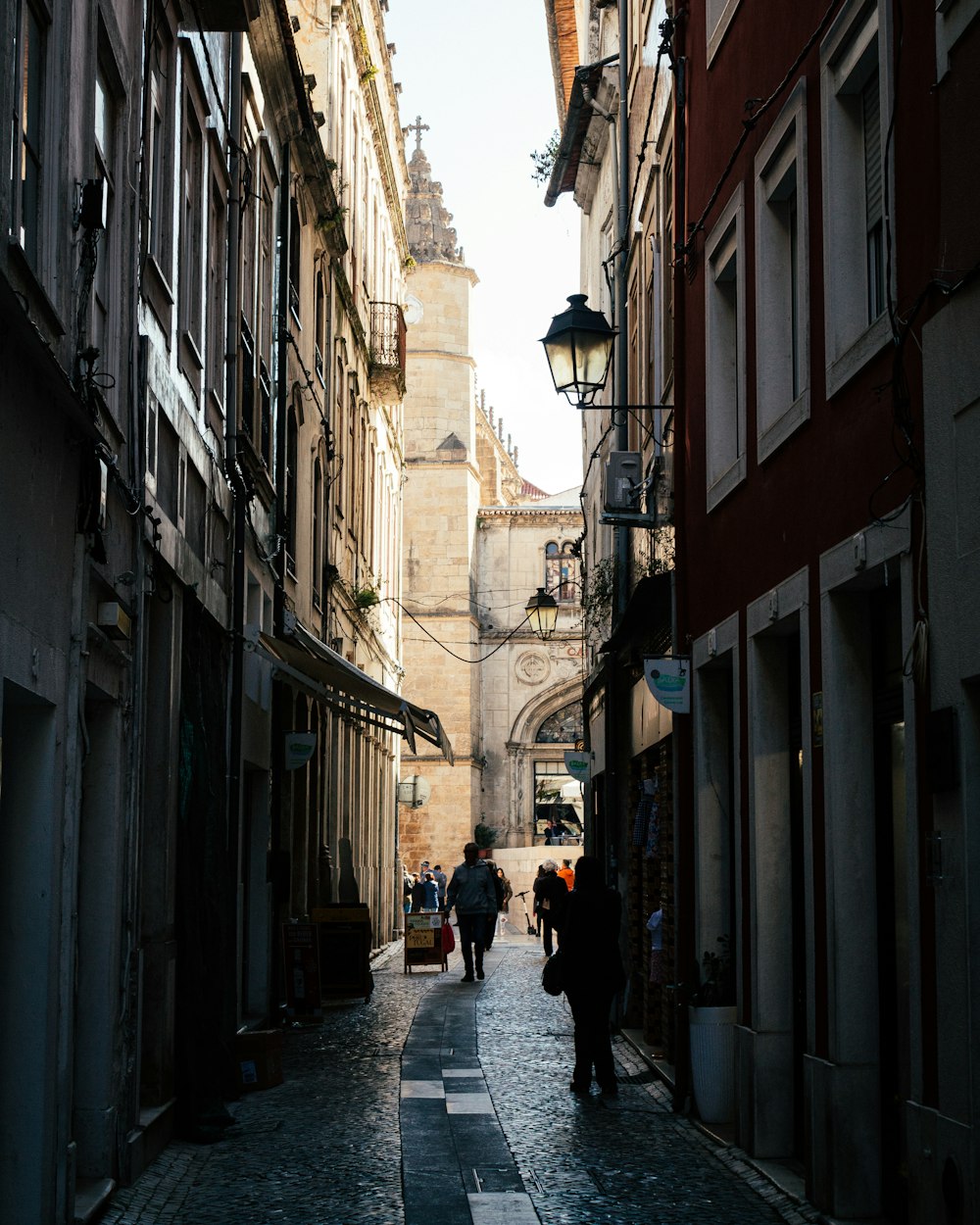 a narrow street with people walking down it