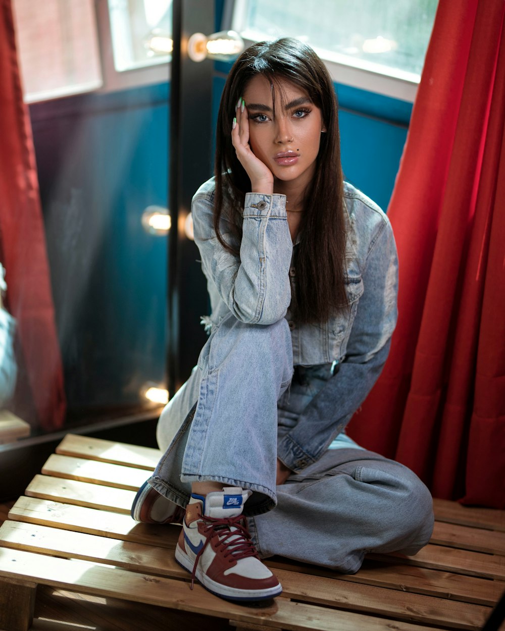 a woman sitting on a wooden bench in a room