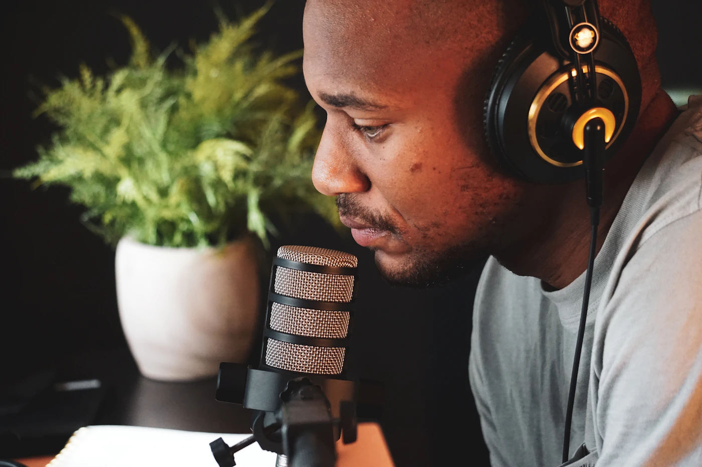 Podcast host recording with headphones and a studio microphone