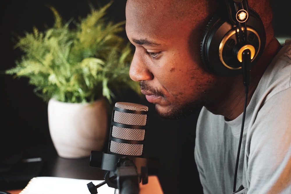 a man wearing headphones is looking at a microphone