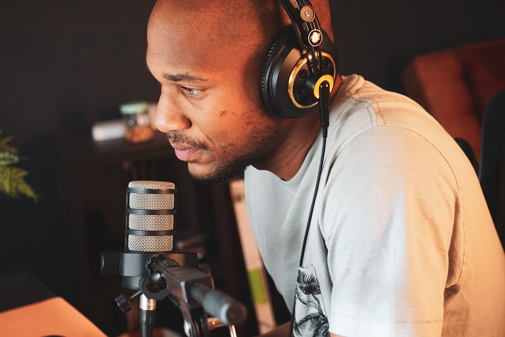 a man wearing headphones sitting in front of a microphone