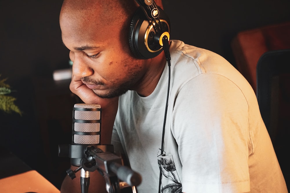 a man wearing headphones sitting in front of a microphone