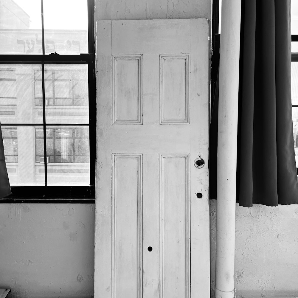 a black and white photo of a door and window