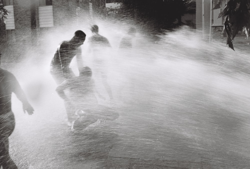 a group of people playing in a water fountain