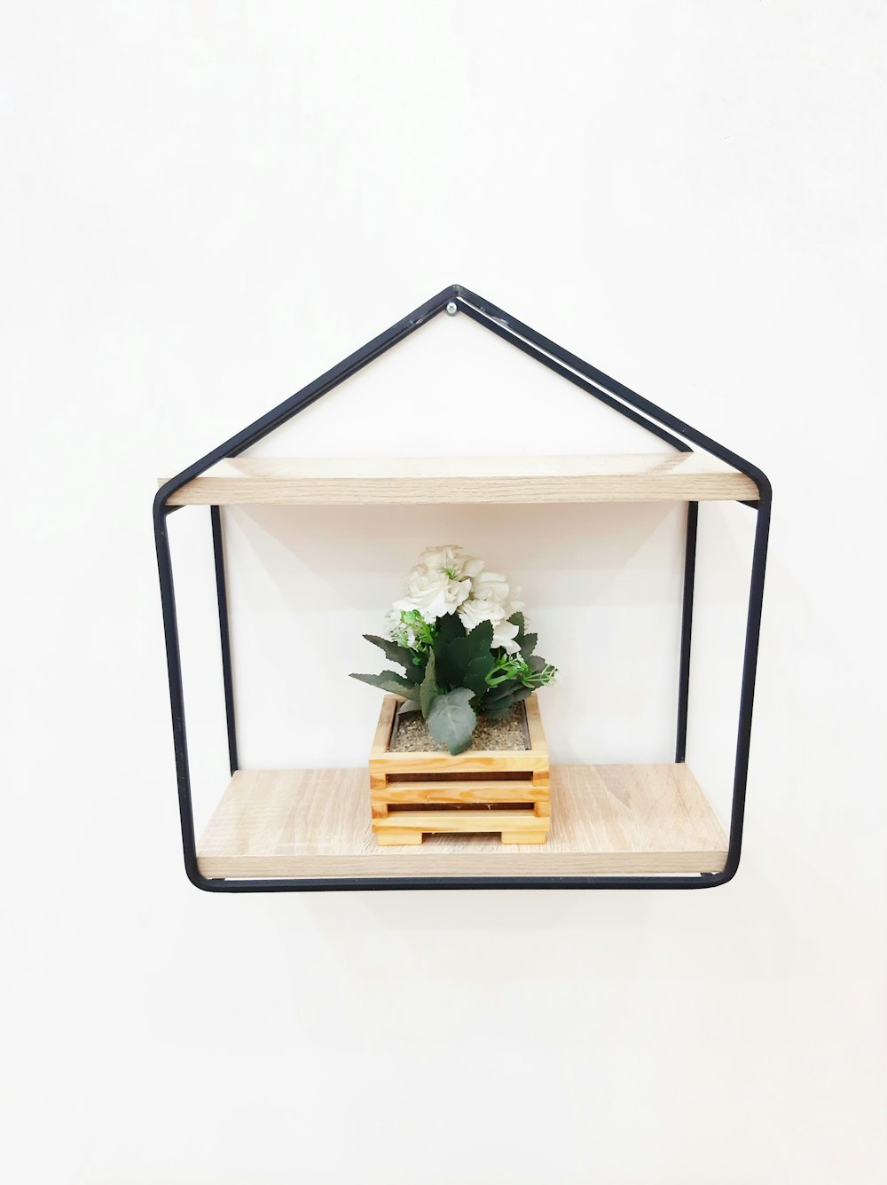 a wooden shelf with a potted plant in it