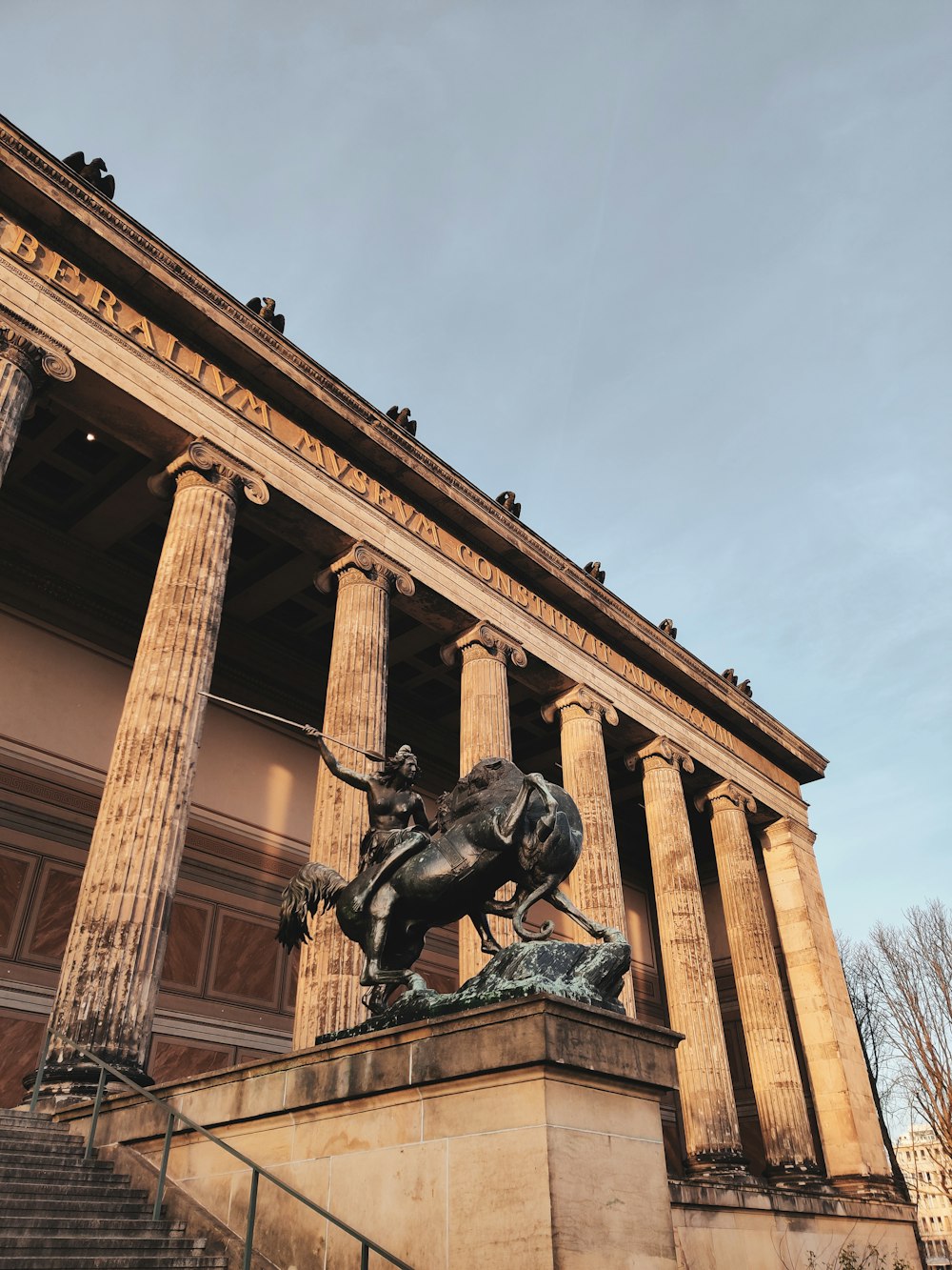 a statue of a man riding a horse in front of a building