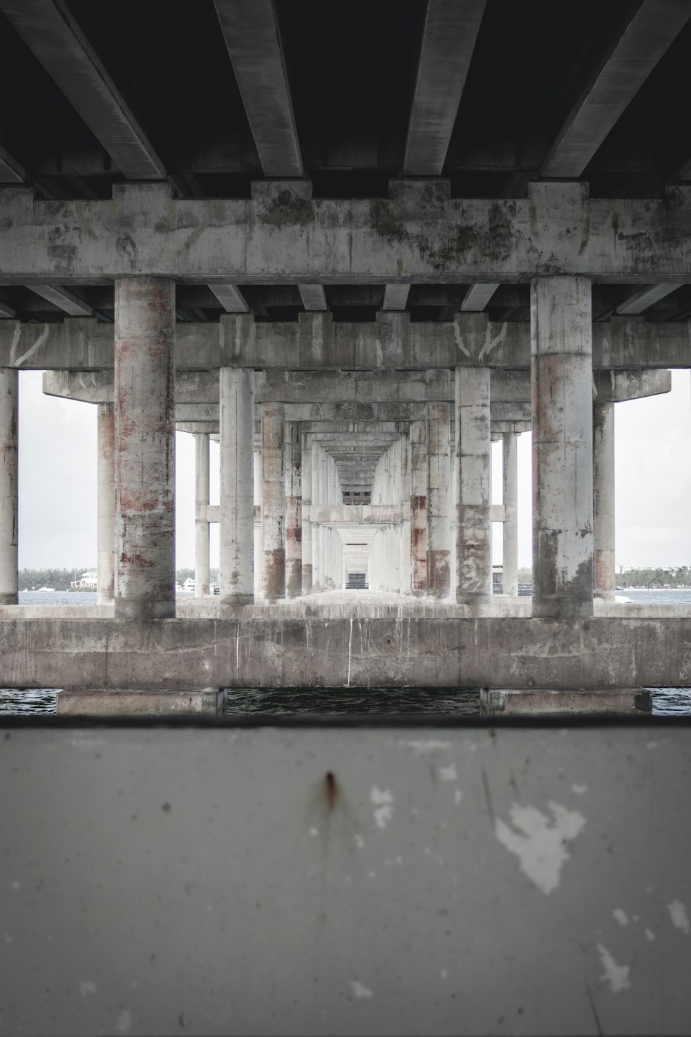 a view of a concrete structure from under a bridge