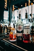 three bottles of alcohol sit on a bar