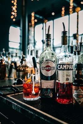 three bottles of alcohol sit on a bar