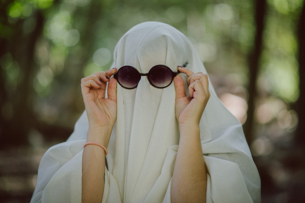 a woman wearing a white shawl covering her eyes