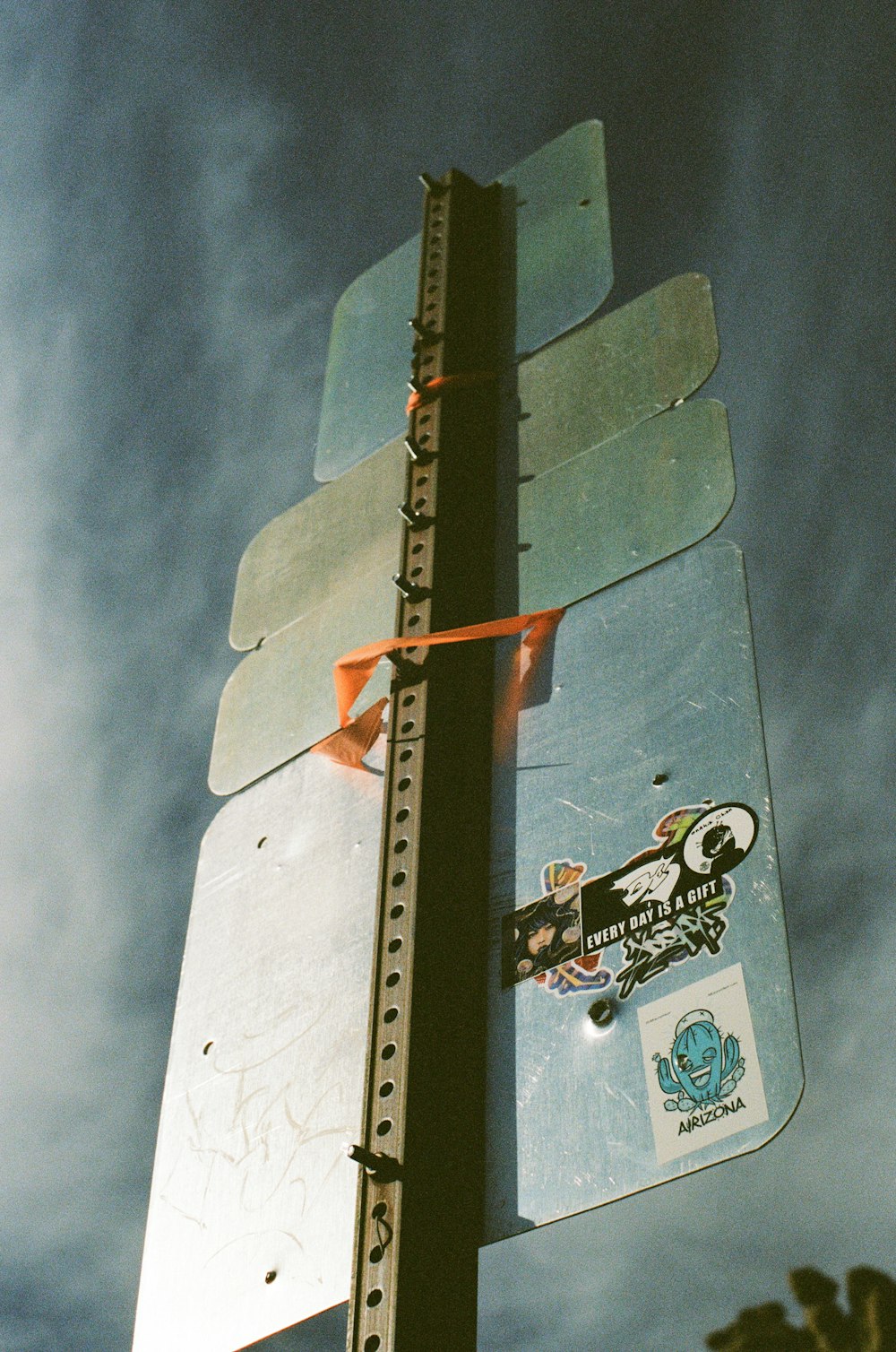 a street sign with stickers attached to it