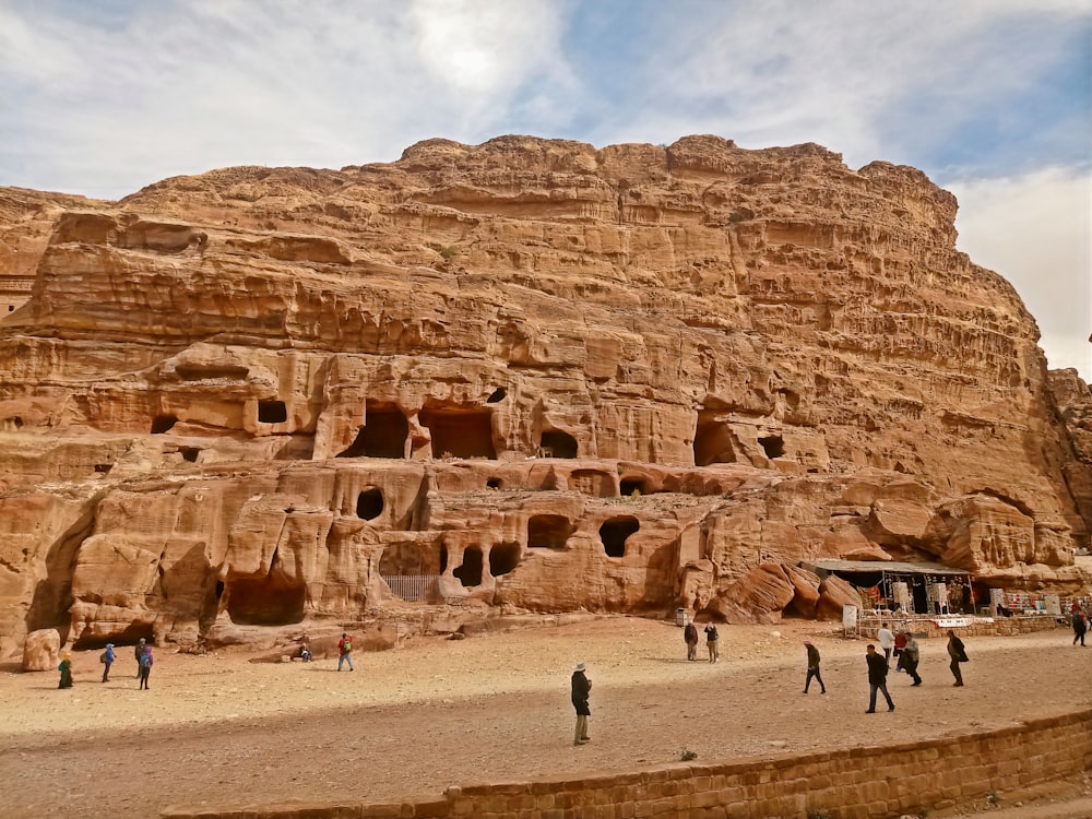 a group of people standing in front of a rock formation