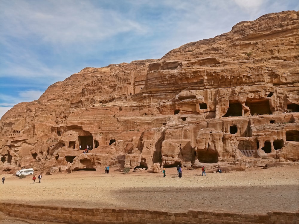 a group of people standing in front of a rock formation