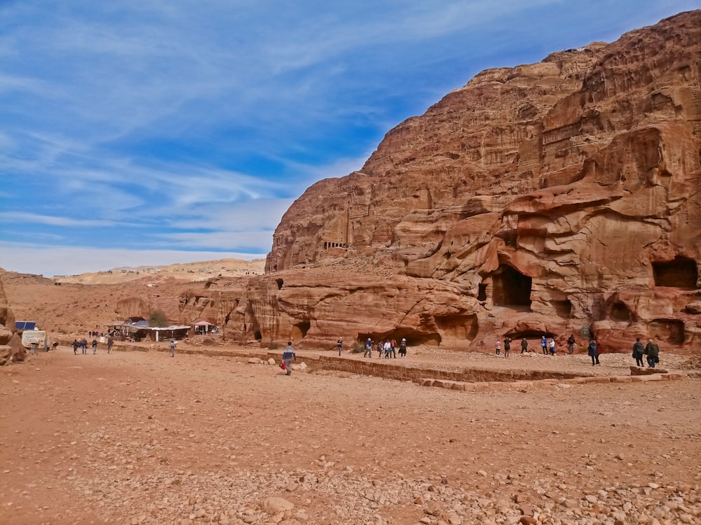 a group of people standing in front of a rock formation