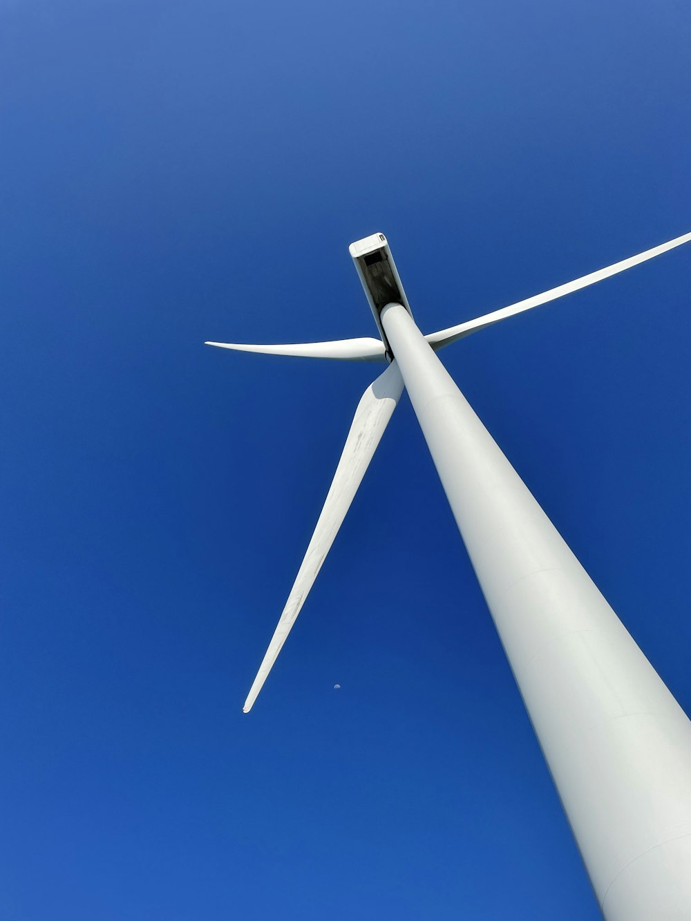 a close up of a wind turbine against a blue sky