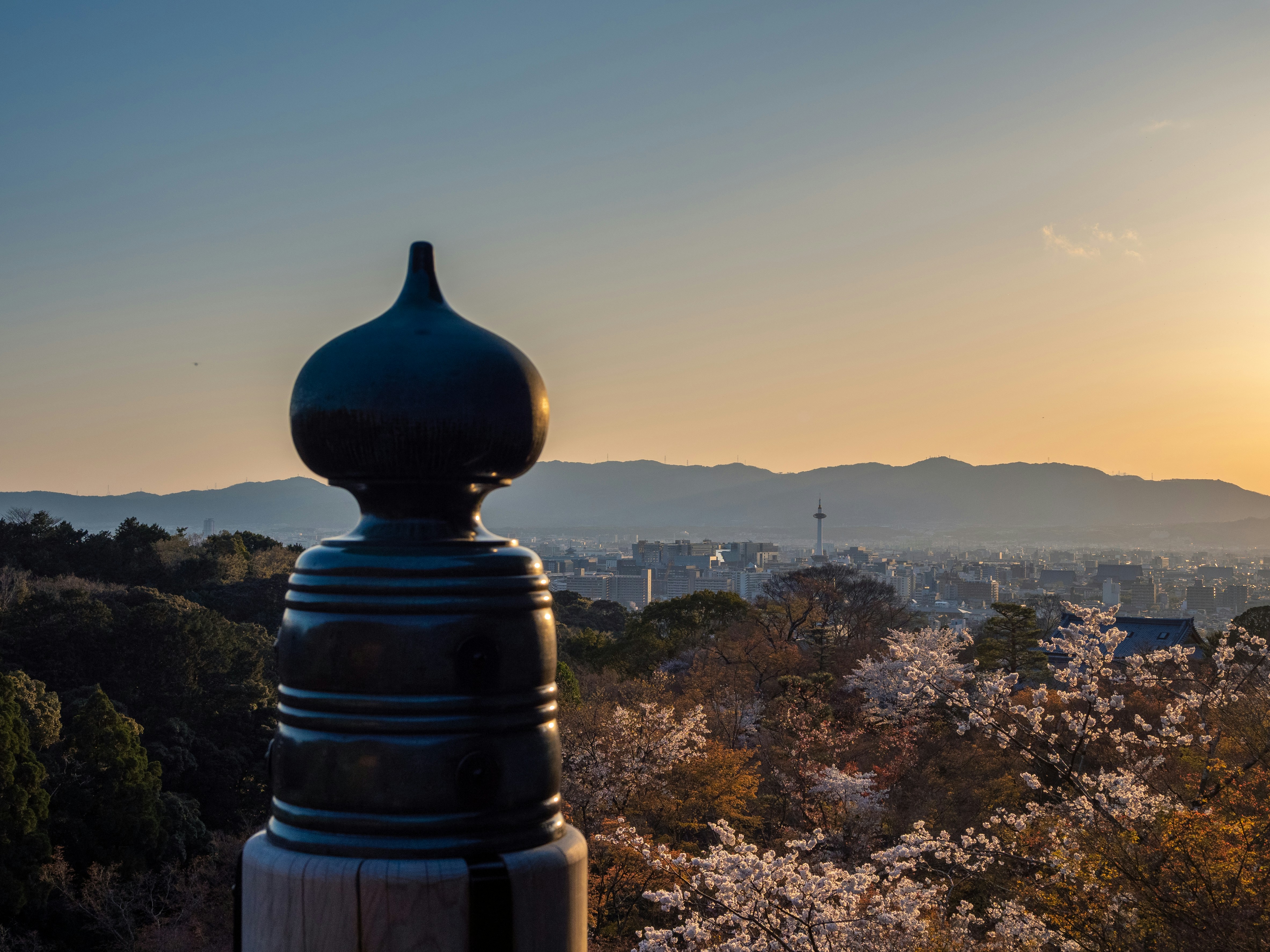 the sun is setting over the mountains and trees