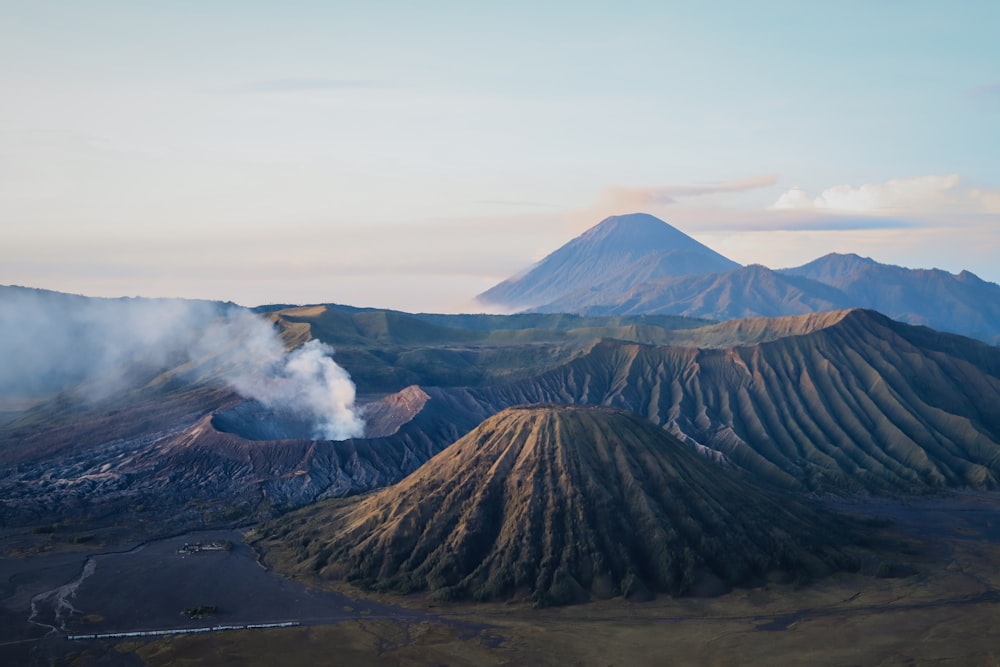 una vista di una catena montuosa con fumo che esce dalla cima