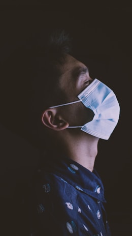 a man wearing a face mask in the dark