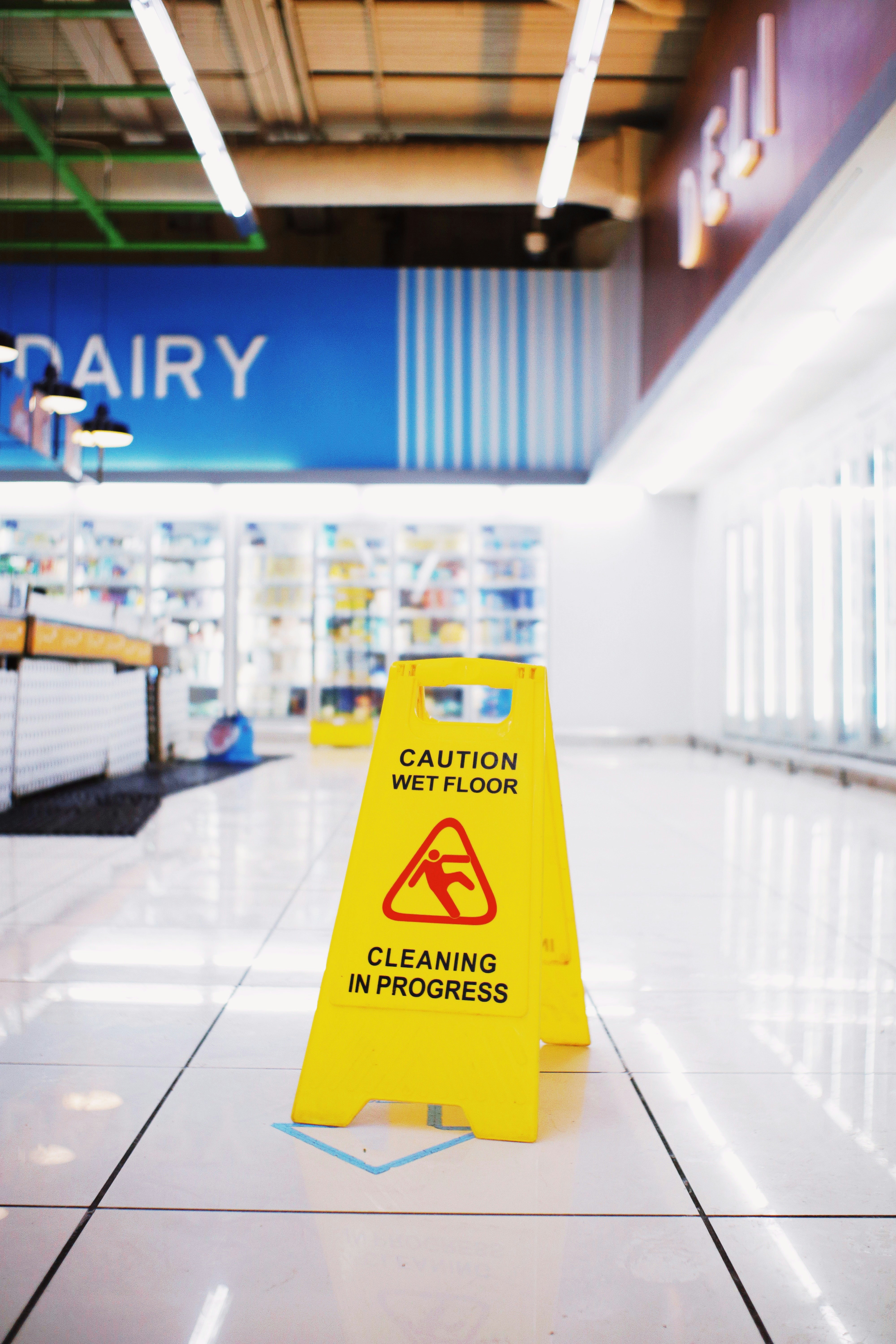 a caution sign sitting on the floor of a store