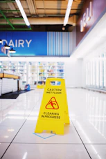 a caution sign sitting on the floor of a store