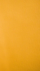 a close up of a yellow painted wall
