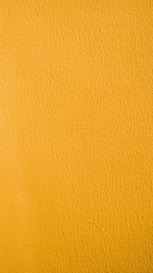 a close up of a yellow painted wall