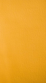 a close up of a yellow painted wall