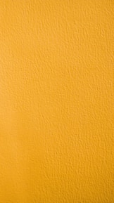 a close up of a yellow painted wall