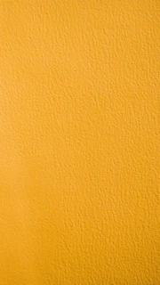 a close up of a yellow painted wall
