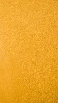 a close up of a yellow painted wall