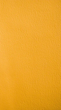 a close up of a yellow painted wall